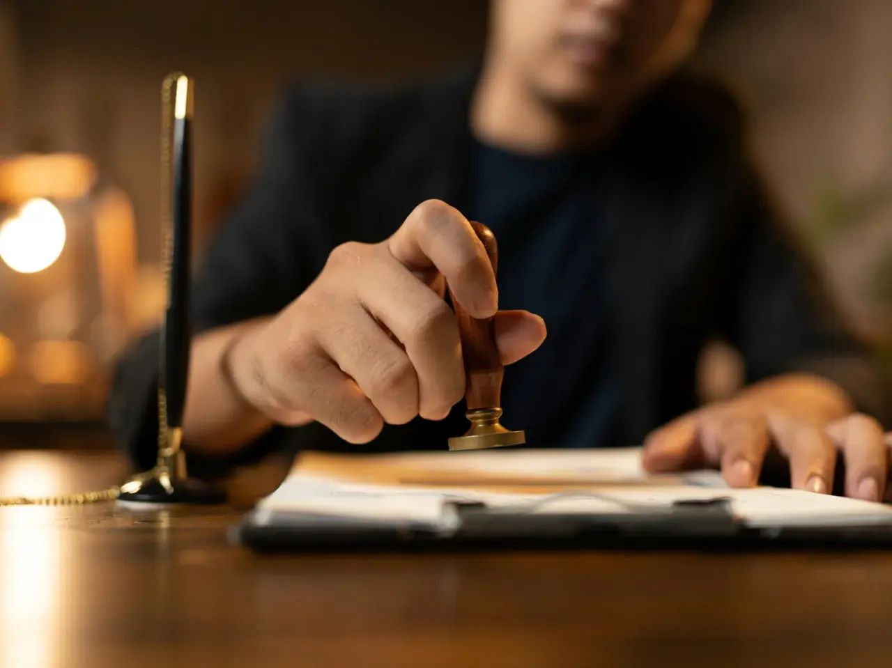 Notary public stamping official documents to verify authenticity and witness signatures in Canada.