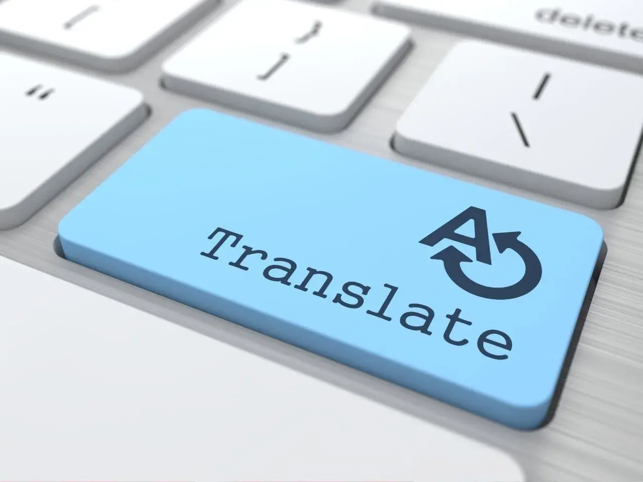 Close-up of a computer keyboard with a blue key labelled “Translate,” featuring an icon of the letter A with a circular arrow, symbolizing language translation.