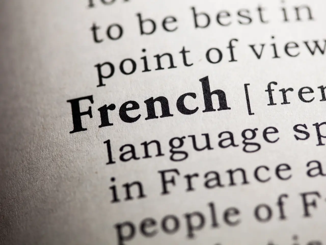 Close-up of the word “French” in a dictionary, symbolizing language learning, translation, or bilingual services.