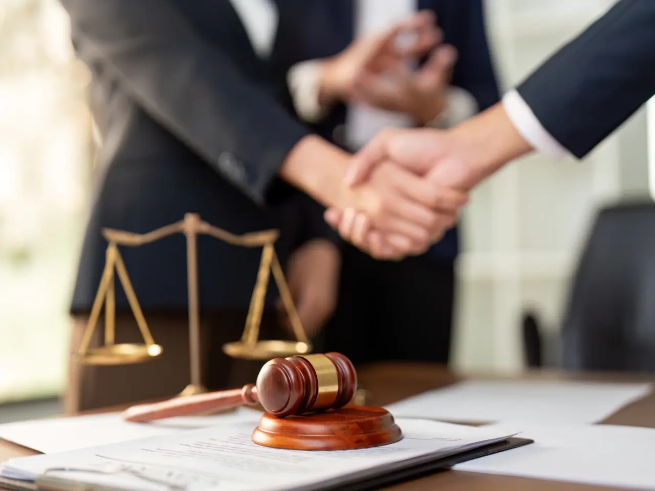 Legal handshake with gavel and scales symbolizing document verification process.