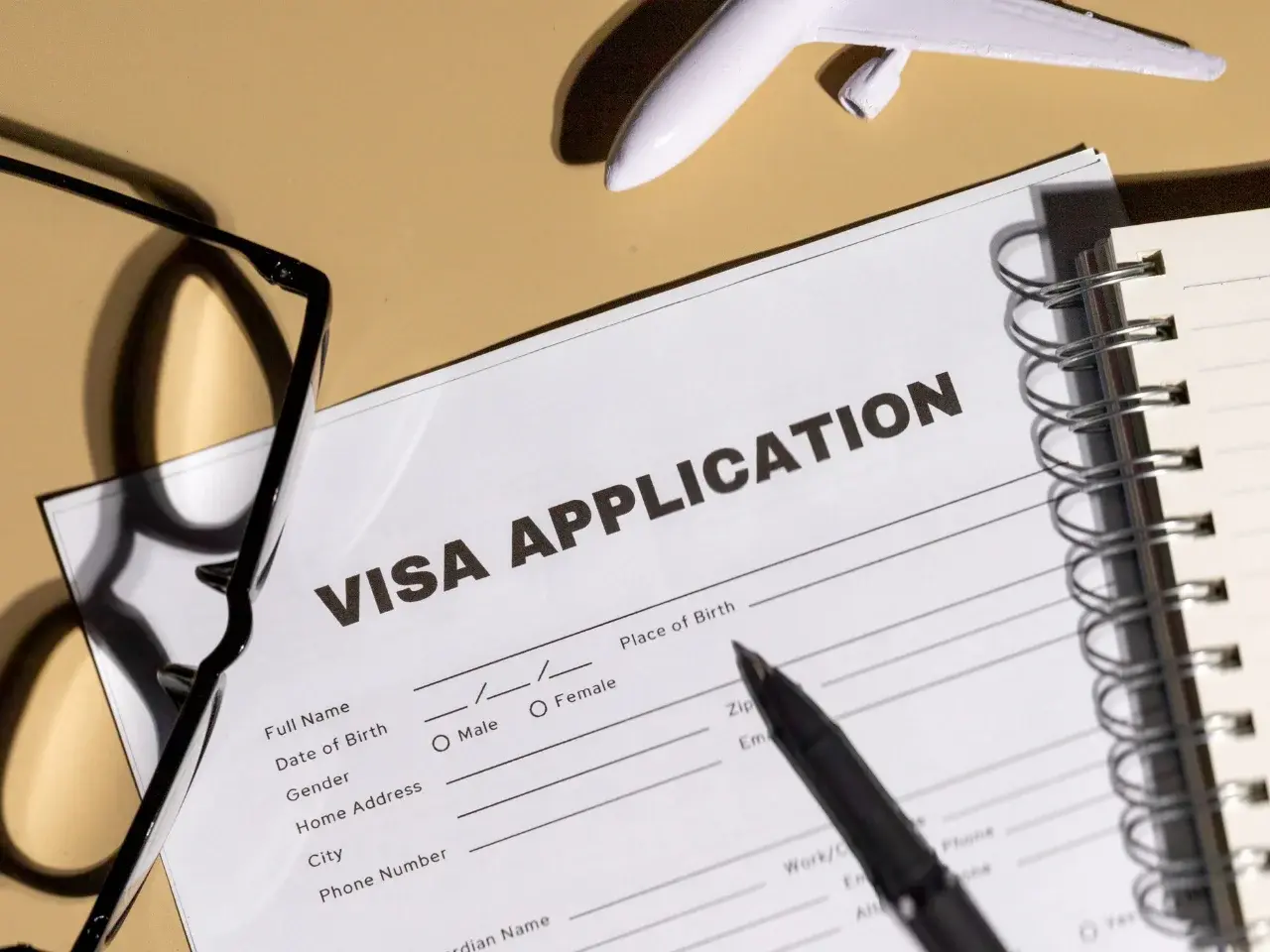 Visa application form with pen and travel essentials for UAE entry requirements.