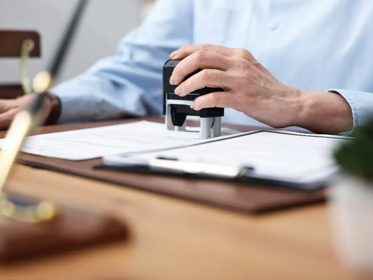 Applying an official stamp to documents as part of the Canadian apostille and authentication process.