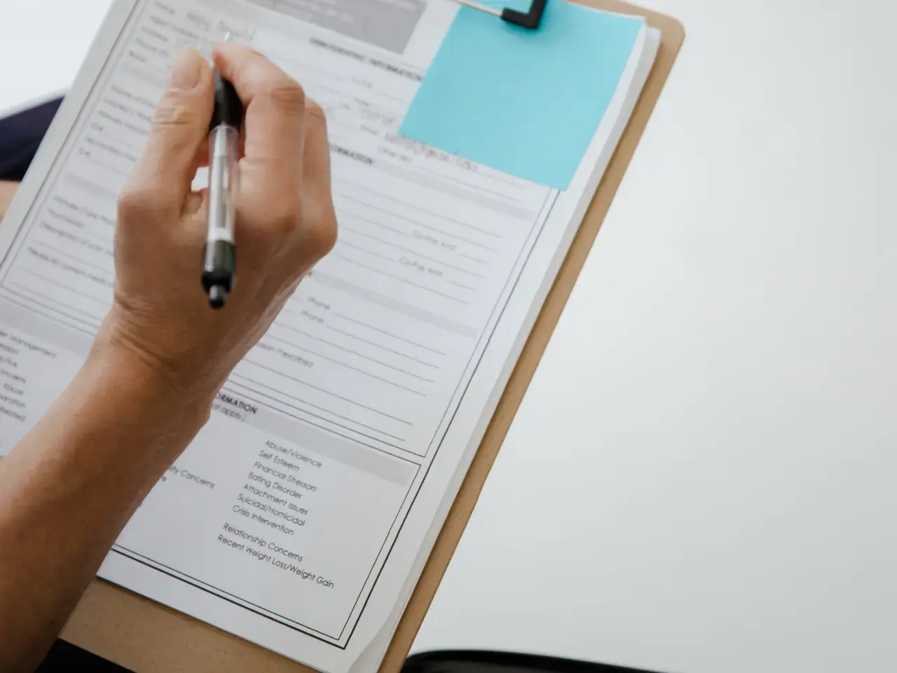 Completing a death certificate application form with required details.