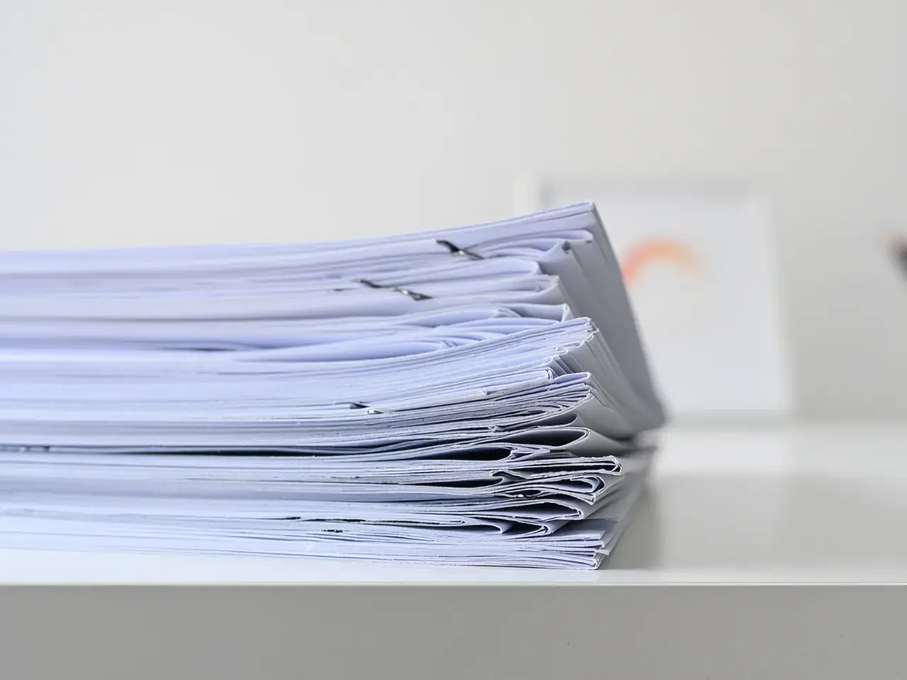 Stack of documents representing multiple copies of a death certificate.