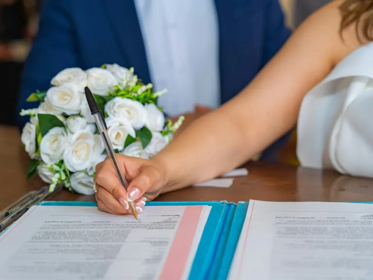Signing documents at a wedding ceremony using an Ontario marriage licence.