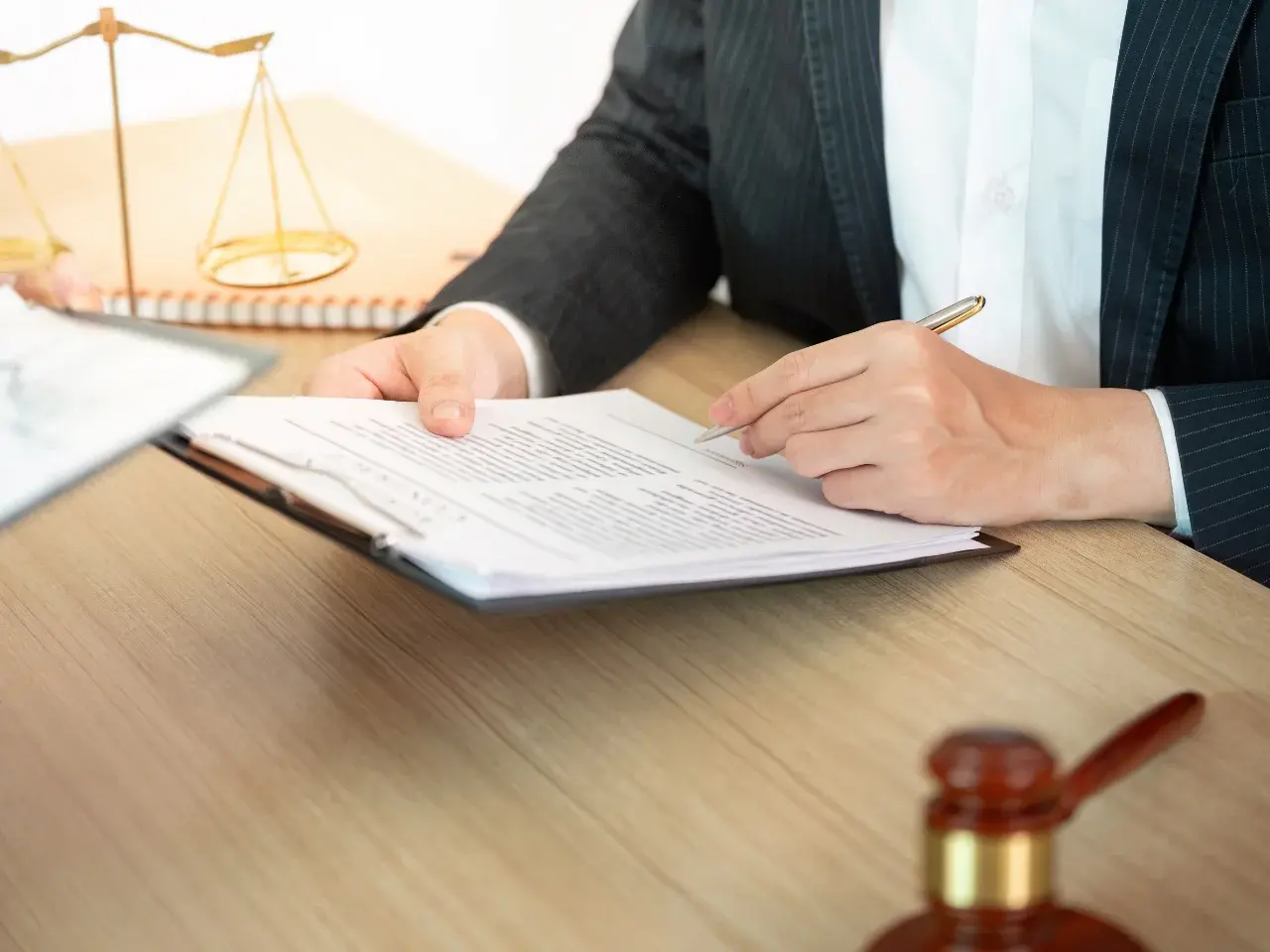 Professional reviewing Canadian legal documents with a justice scale and a gavel on a desk.