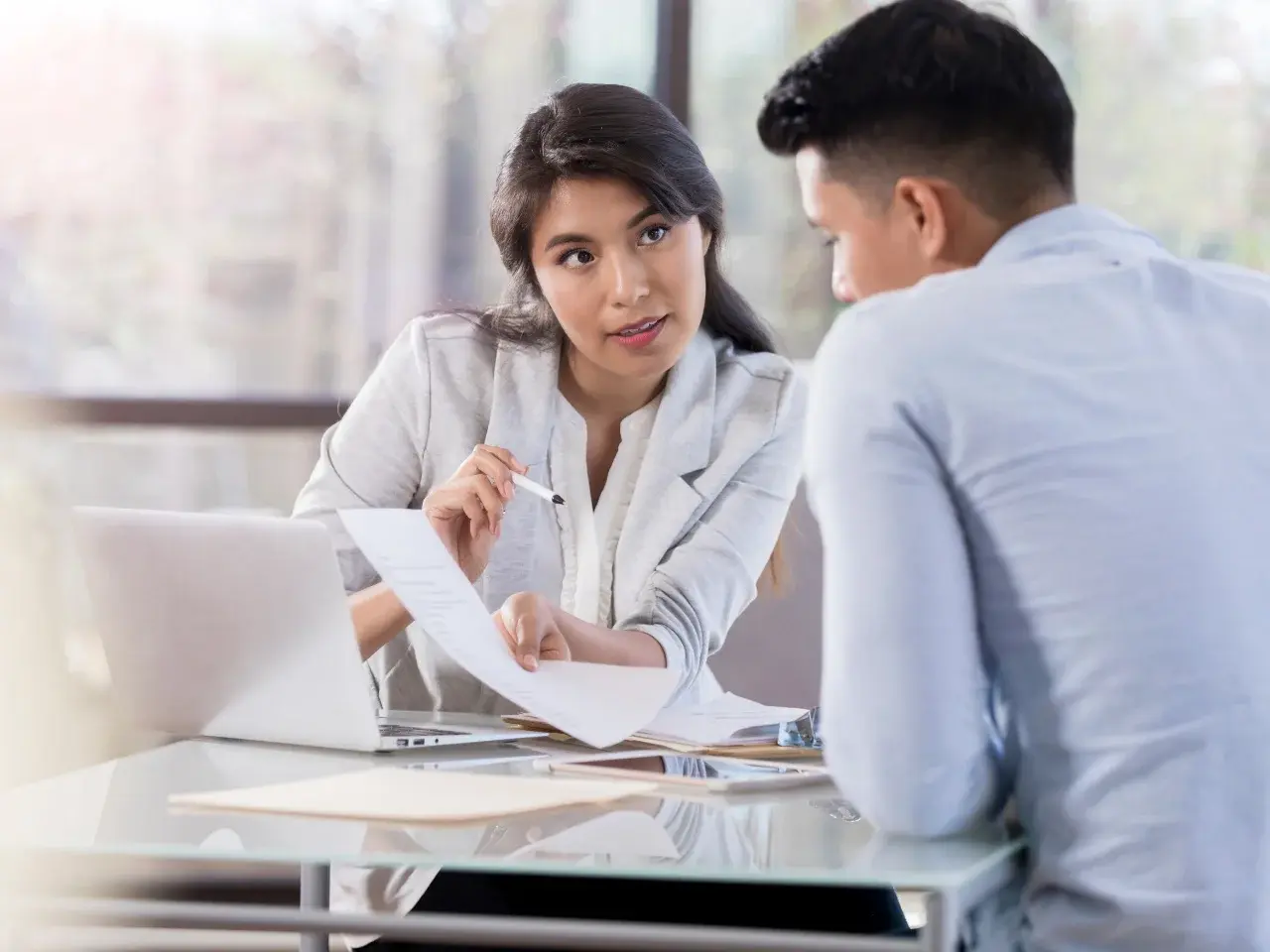 Two people in the office are discussing apostille and authentication paperwork.