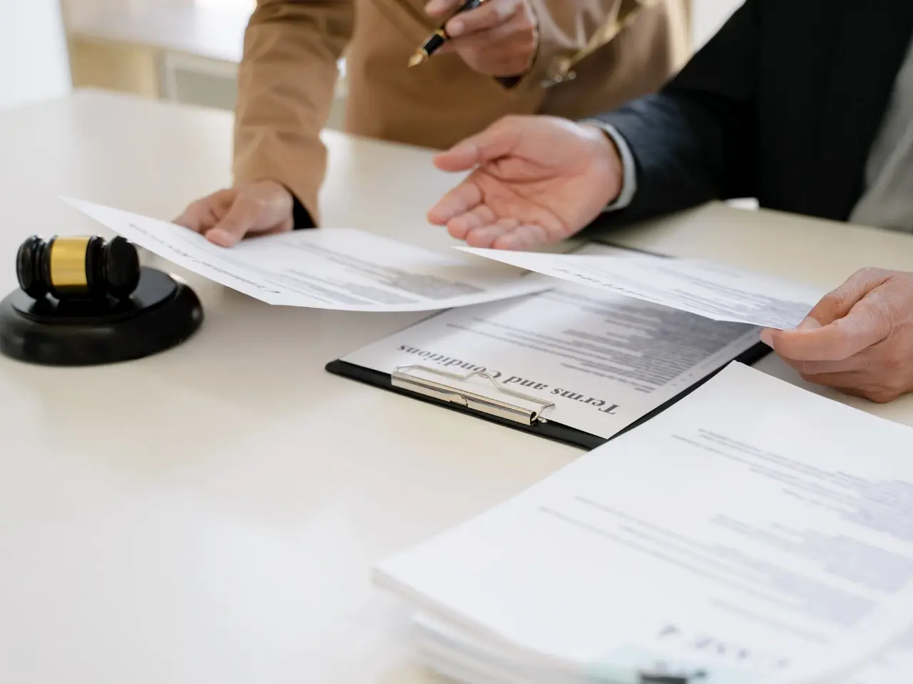 Two professionals reviewing legal documents with a gavel on the desk, symbolizing document legalization and authentication in Canada.