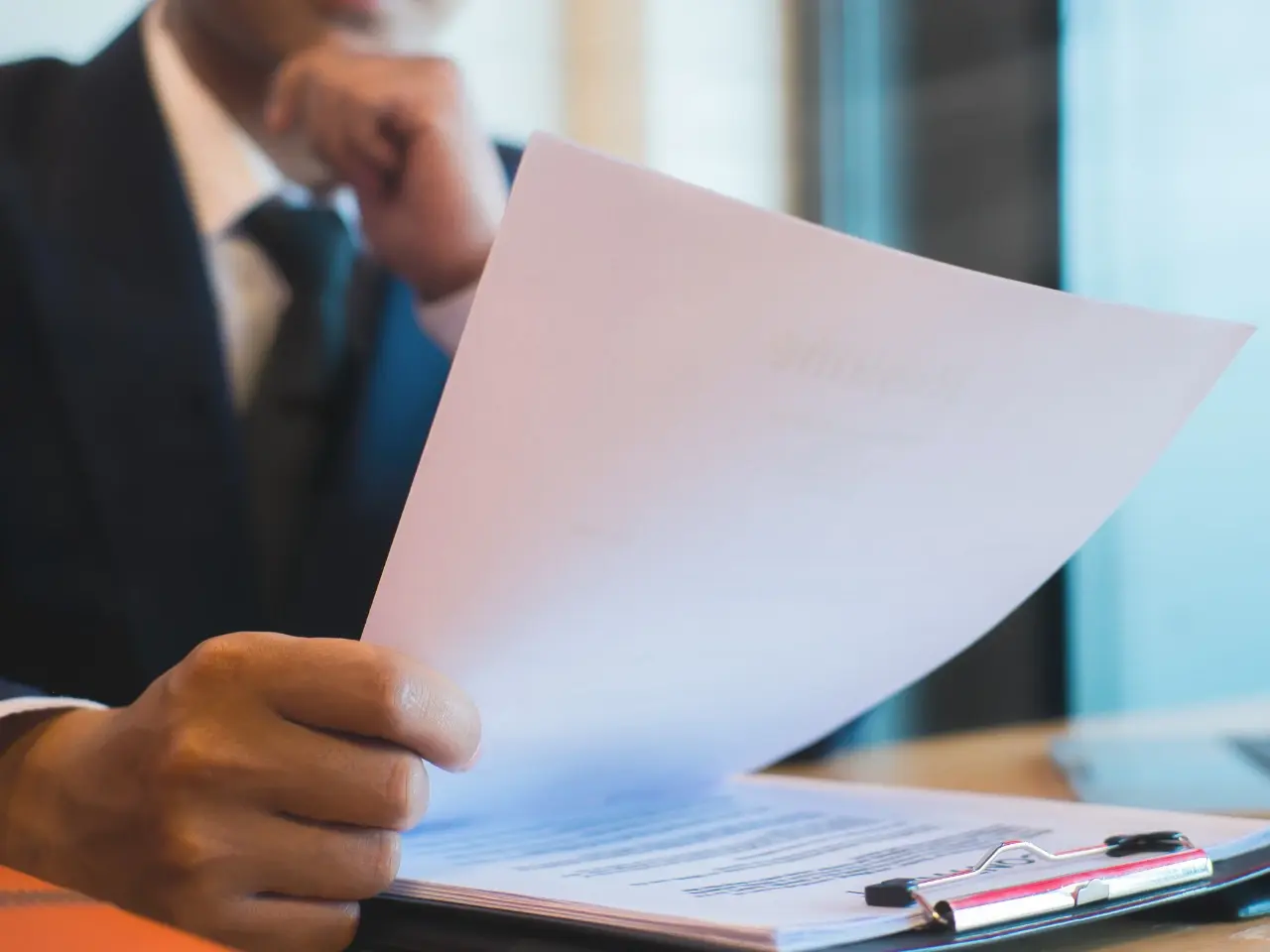 Lawyer reviewing a legal document with a clipboard, symbolizing the process of authentication and legalization of paperwork in Canada.