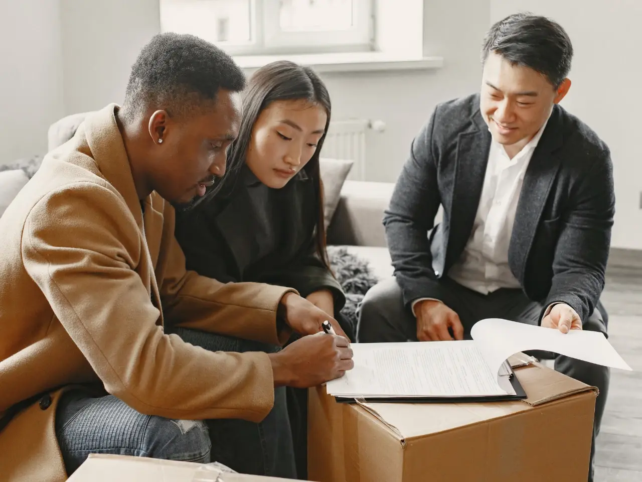 Couple signing official documents with a consultant, representing support with certified translations for immigration or legal purposes.