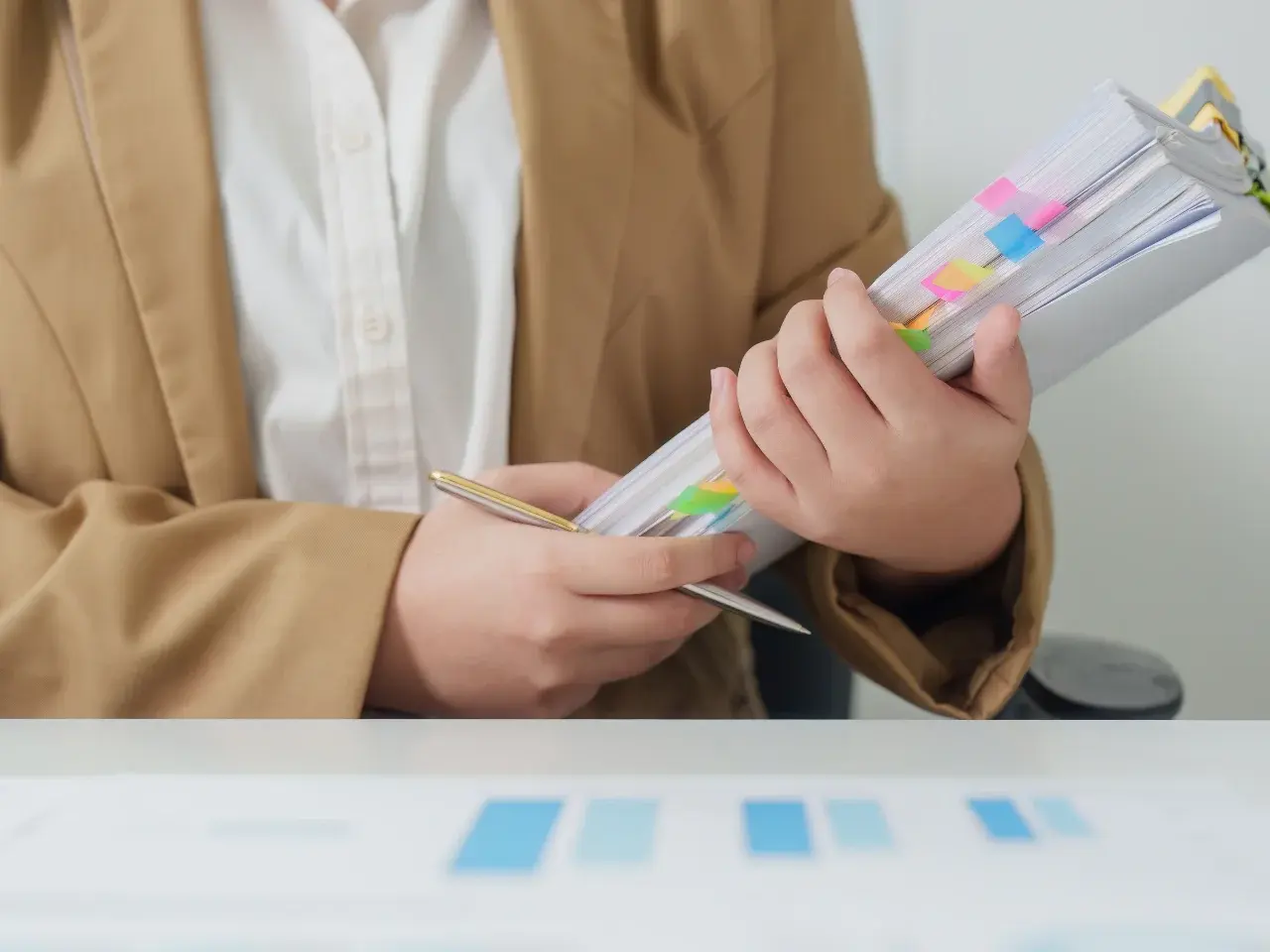 An individual holding organized files and prepared documents.