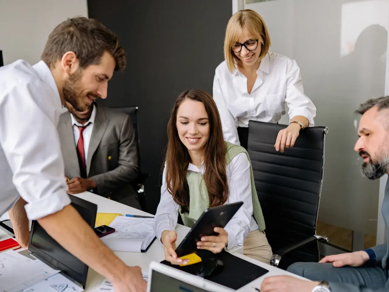 A diverse group of business professionals, collaborating in a modern office, determines the best localization and translation strategy for an international project.