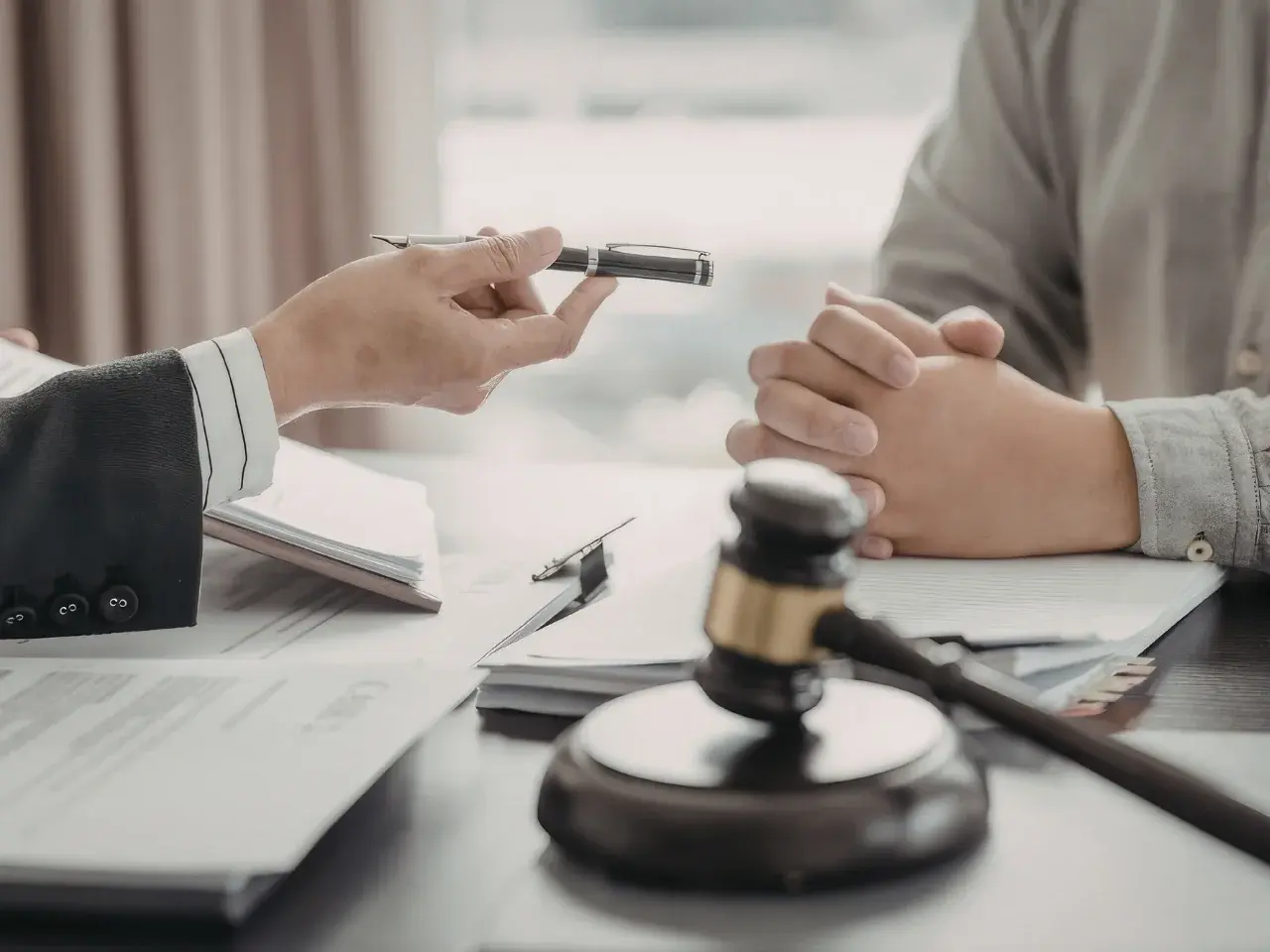 Client is signing official documents, with a wooden gavel in the foreground symbolizing legal authority and the successful legalization of the documents.