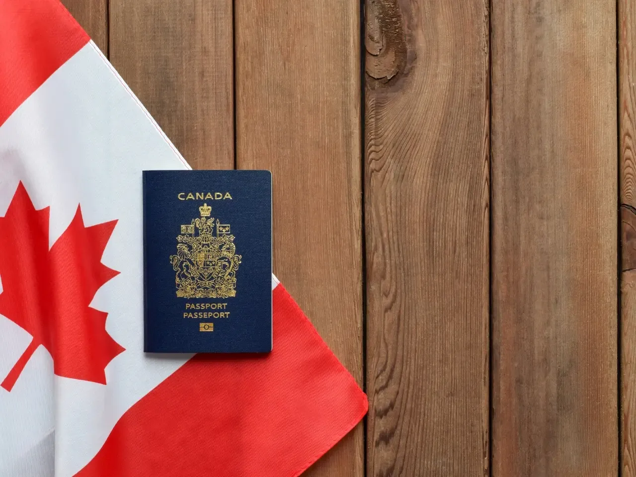 Canadian passport placed beside a flag, symbolizing the additional documents needed for marriage abroad when Canada cannot issue a certificate of non-impediment.
