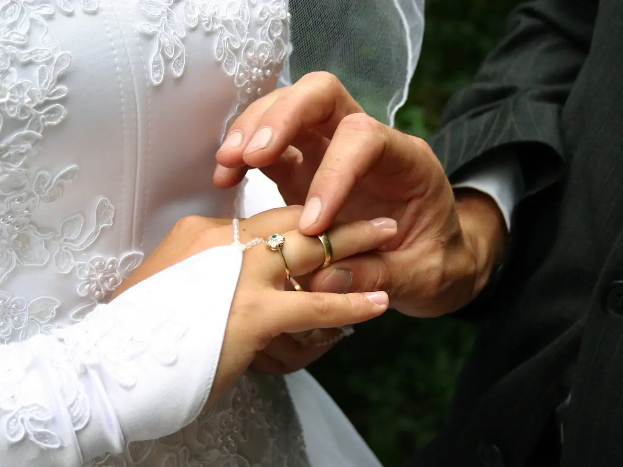 Couple exchanging wedding rings, representing Canadians planning to marry overseas and the documentation requirements involved.