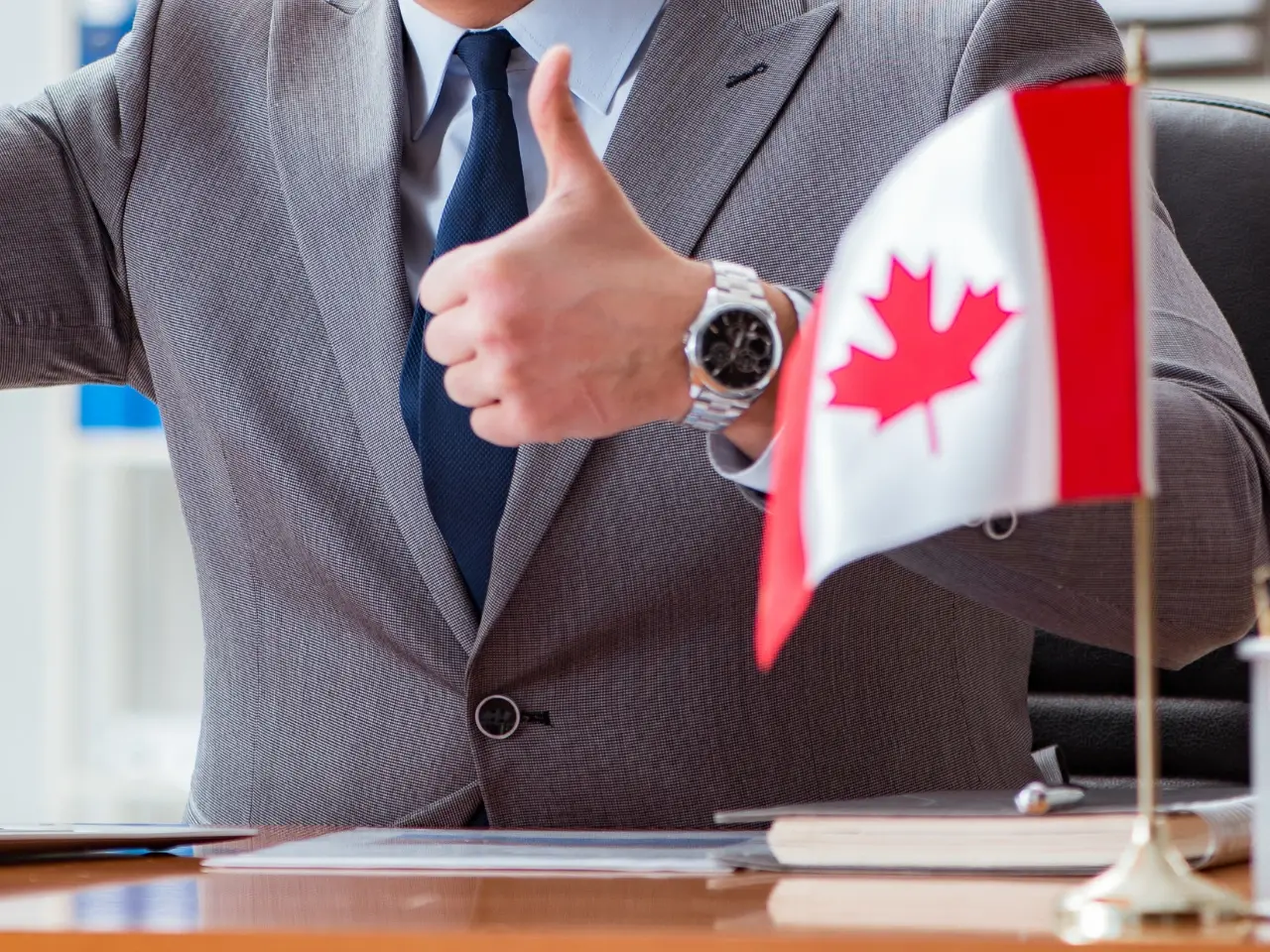 Professional giving a thumbs-up beside a Canadian flag, symbolizing smooth assistance with obtaining and preparing a statement in lieu of certificate of non-impediment.