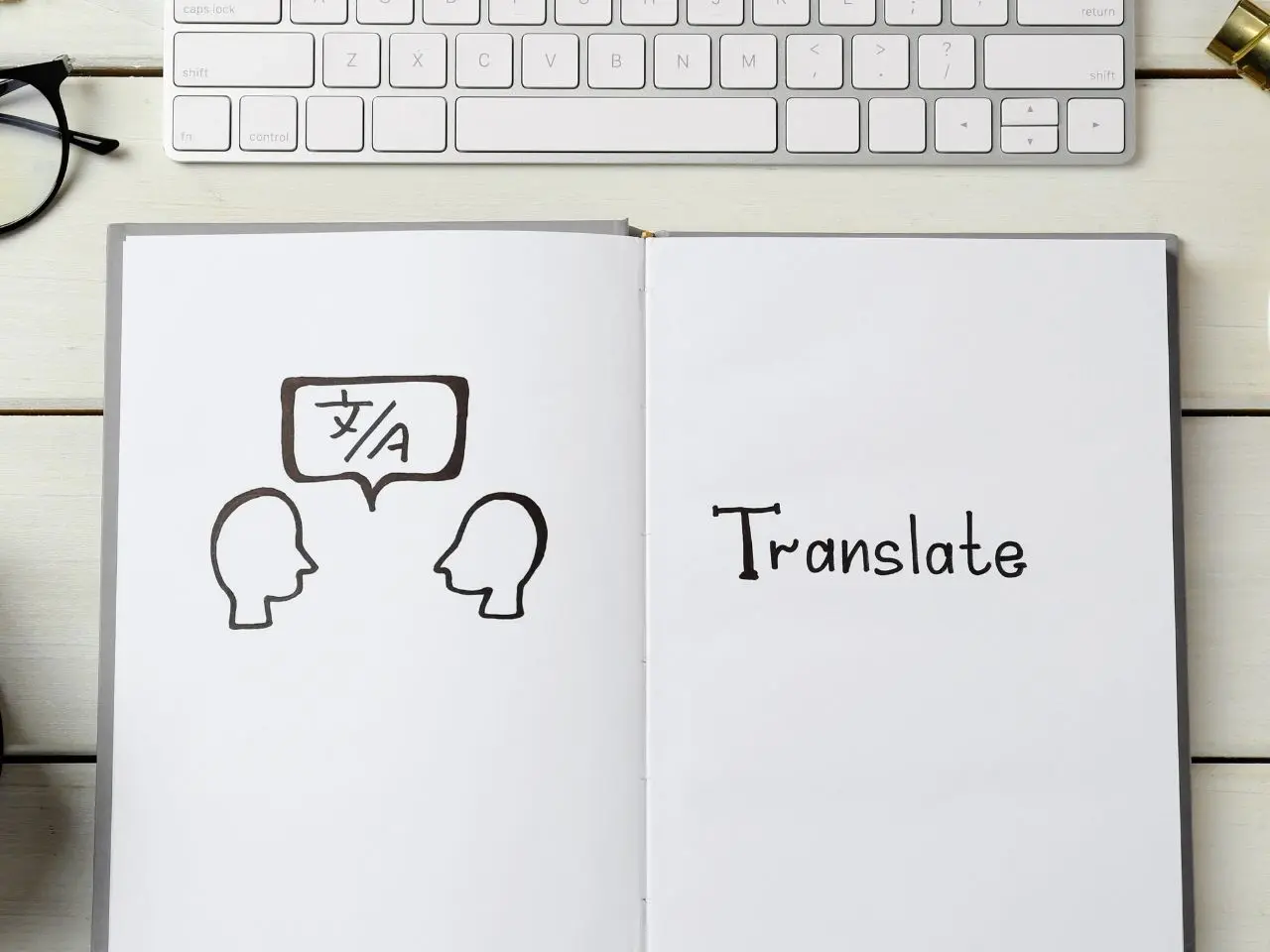 Open notebook with a hand-drawn illustration of two people speaking in different languages and the word “Translate,” symbolizing language translation services.