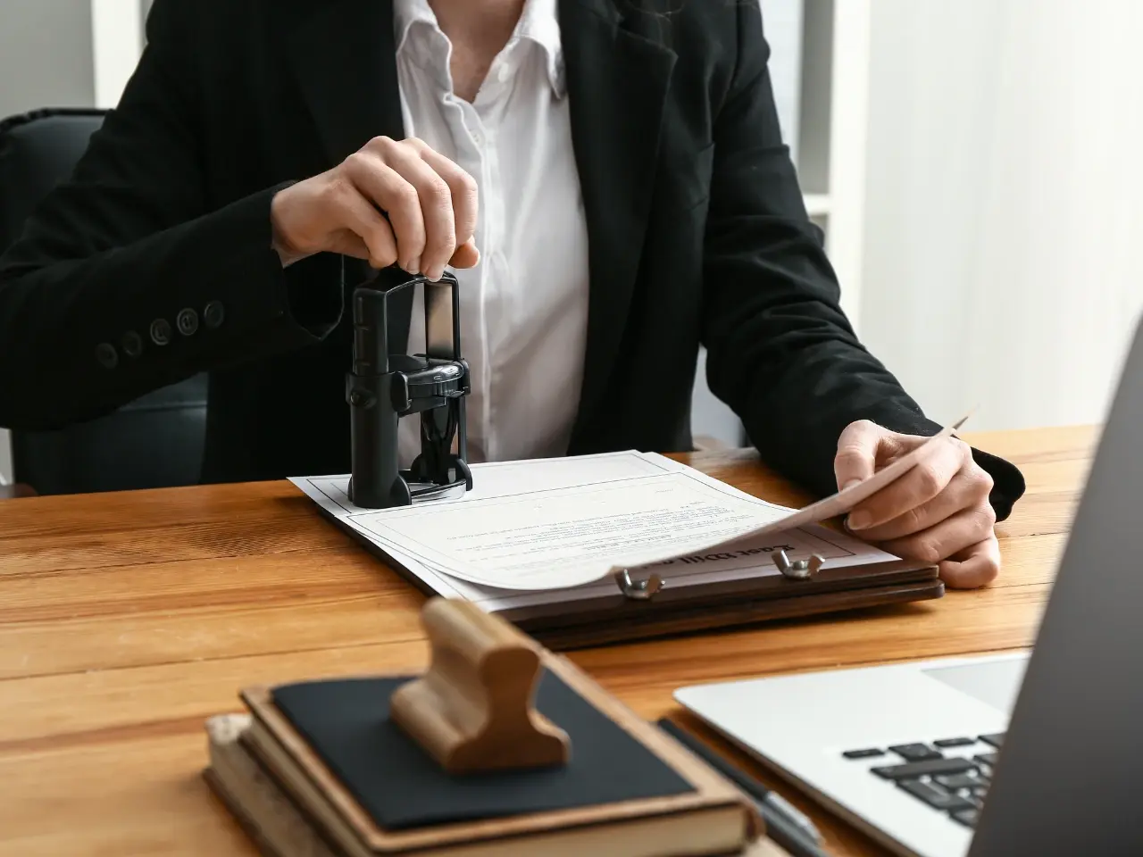 Professional applying a notary-style stamp to a legal document, illustrating the official certification of translated papers.