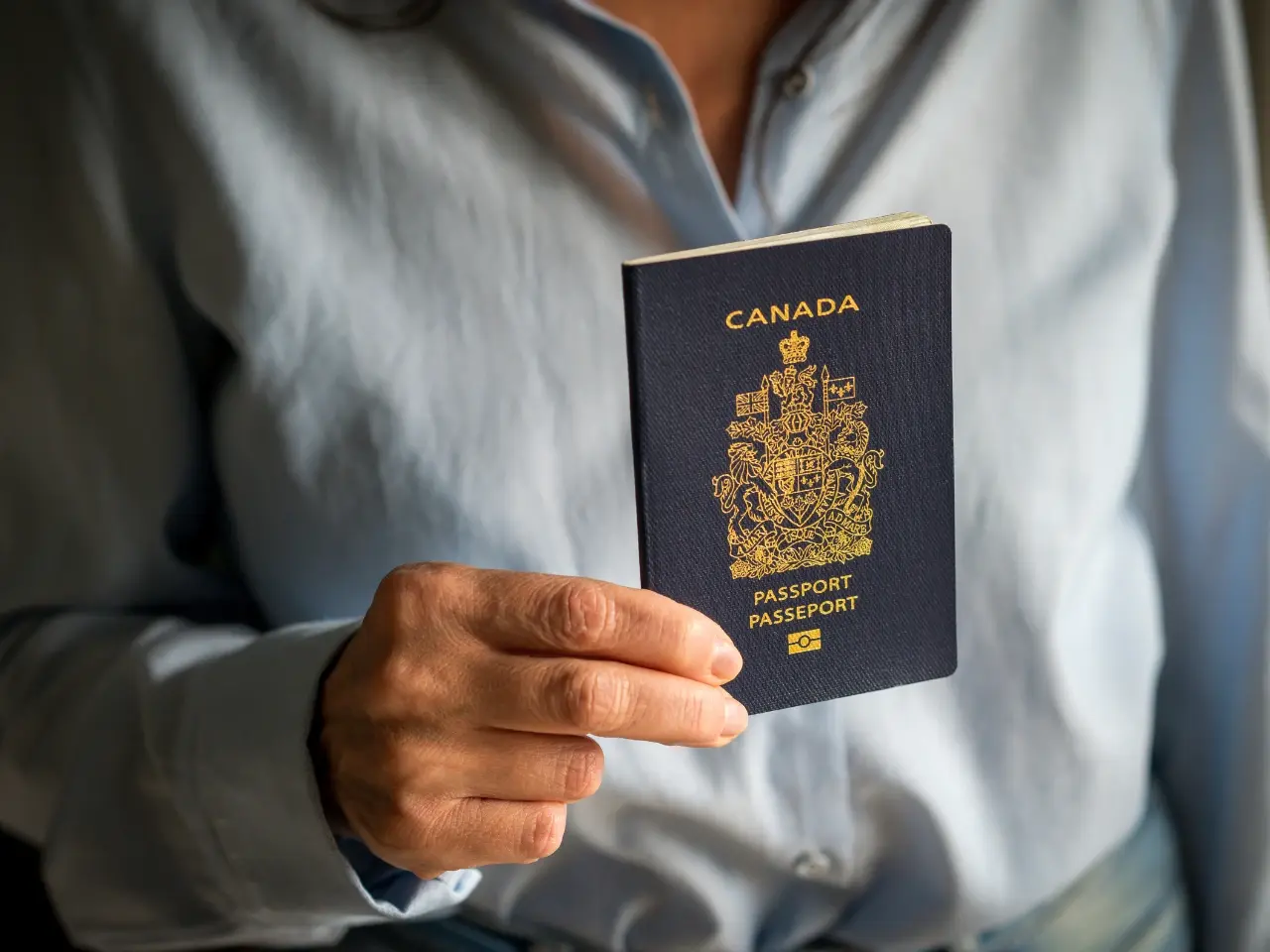Person holding a Canadian passport, symbolizing common situations requiring an apostille for international travel, immigration, or legal use.