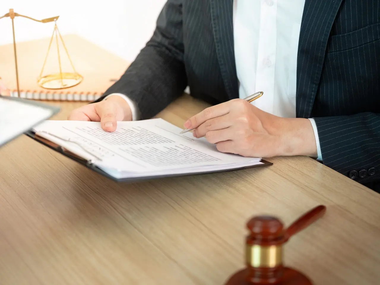 Professional reviewing legal paperwork with a gavel nearby, representing full-service apostille, authentication, and legalization assistance.