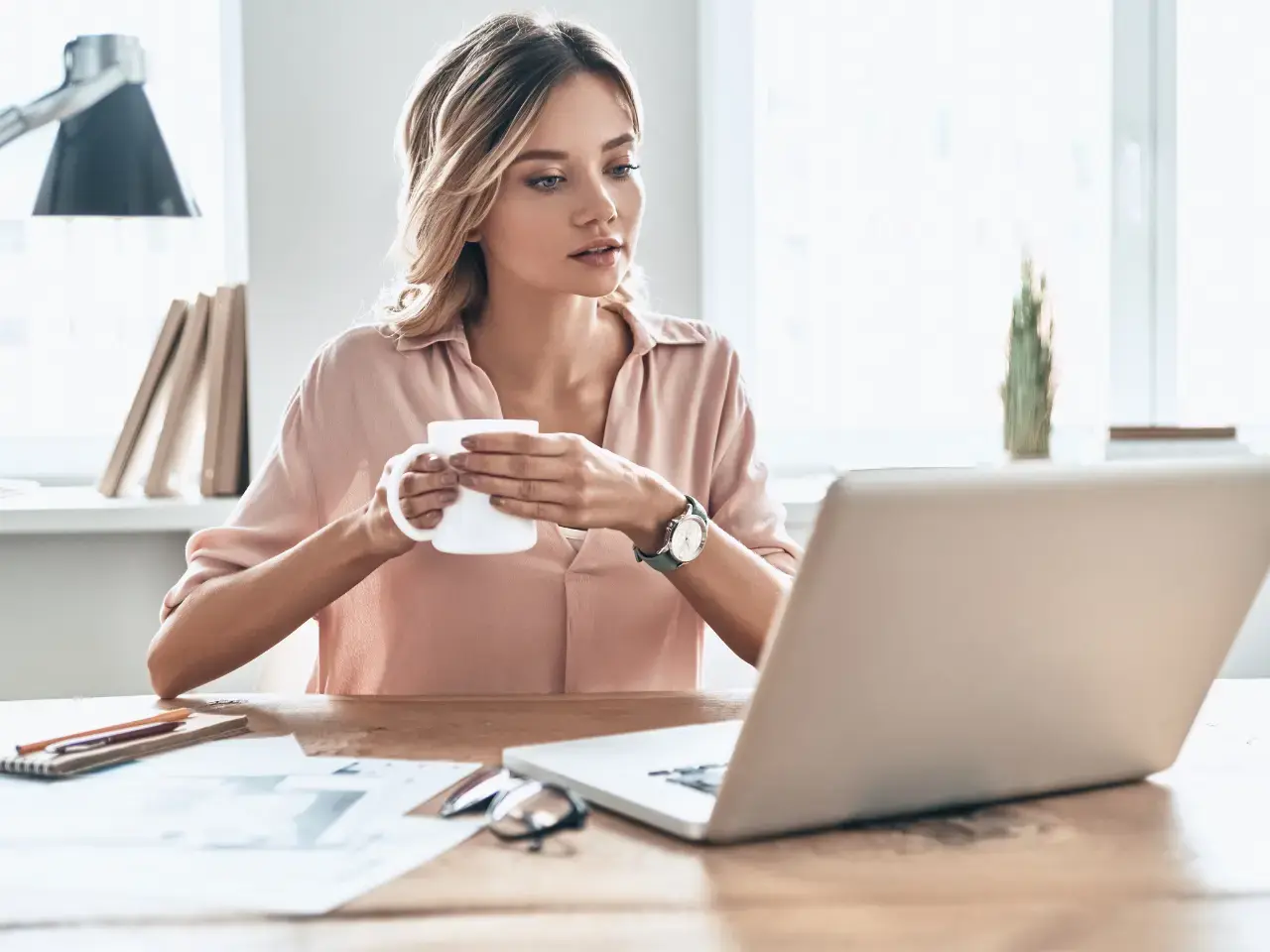Woman reviewing documents at her desk, representing how residency status is determined based on ties to Canada and tax treaty rules.
