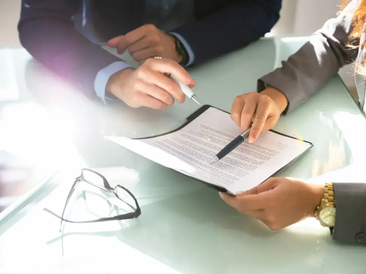Professionals reviewing paperwork together, representing assistance with apostille, authentication, legalization, and certified translation for CRA-issued tax residency certificates used abroad.