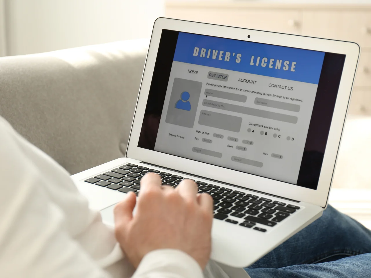 Person completing an Alberta driver's licence application and identity information online.