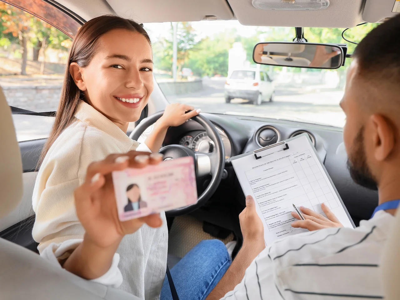 New driver holding a driver's licence during a driving lesson, representing Quebec driver's licence classes and licensing requirements.