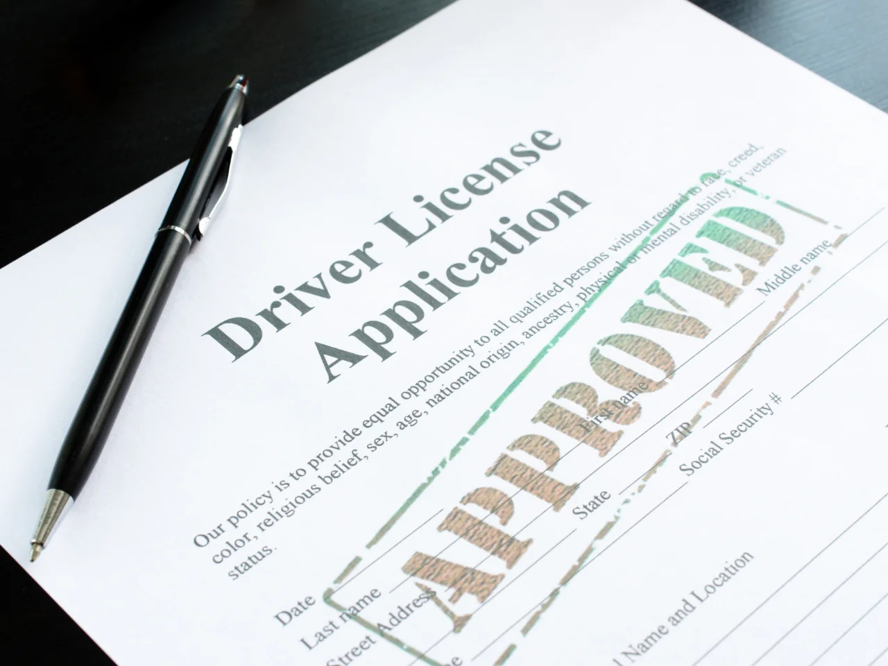 Approved driver's licence application form with a pen, representing a successful Quebec driver's licence exchange application.