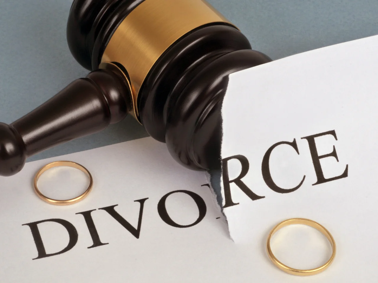 Judge's gavel and wedding rings on torn divorce papers representing the legal divorce process in Canada.