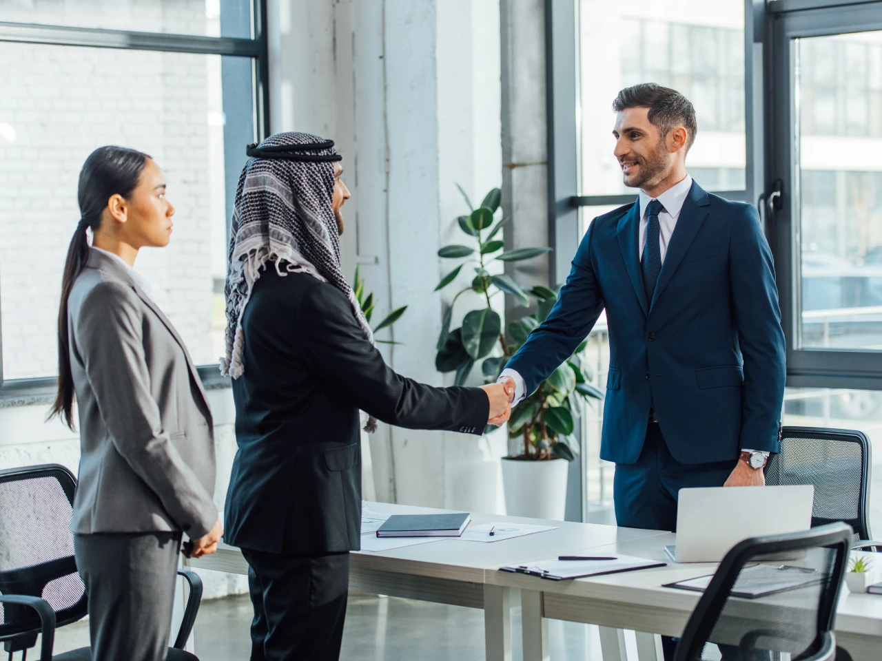 International business partners shaking hands after a meeting.